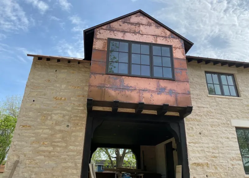 Copper metal panel facade on a stone building for Roof Repair in Old Westbury